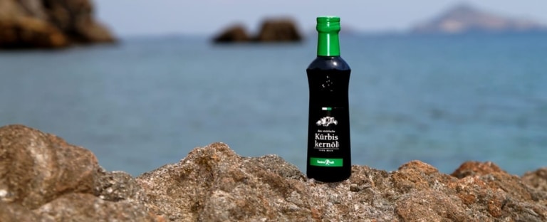 Flasche Steirisches Kürbiskernöl g.g.A. am Strand mit Meerblick